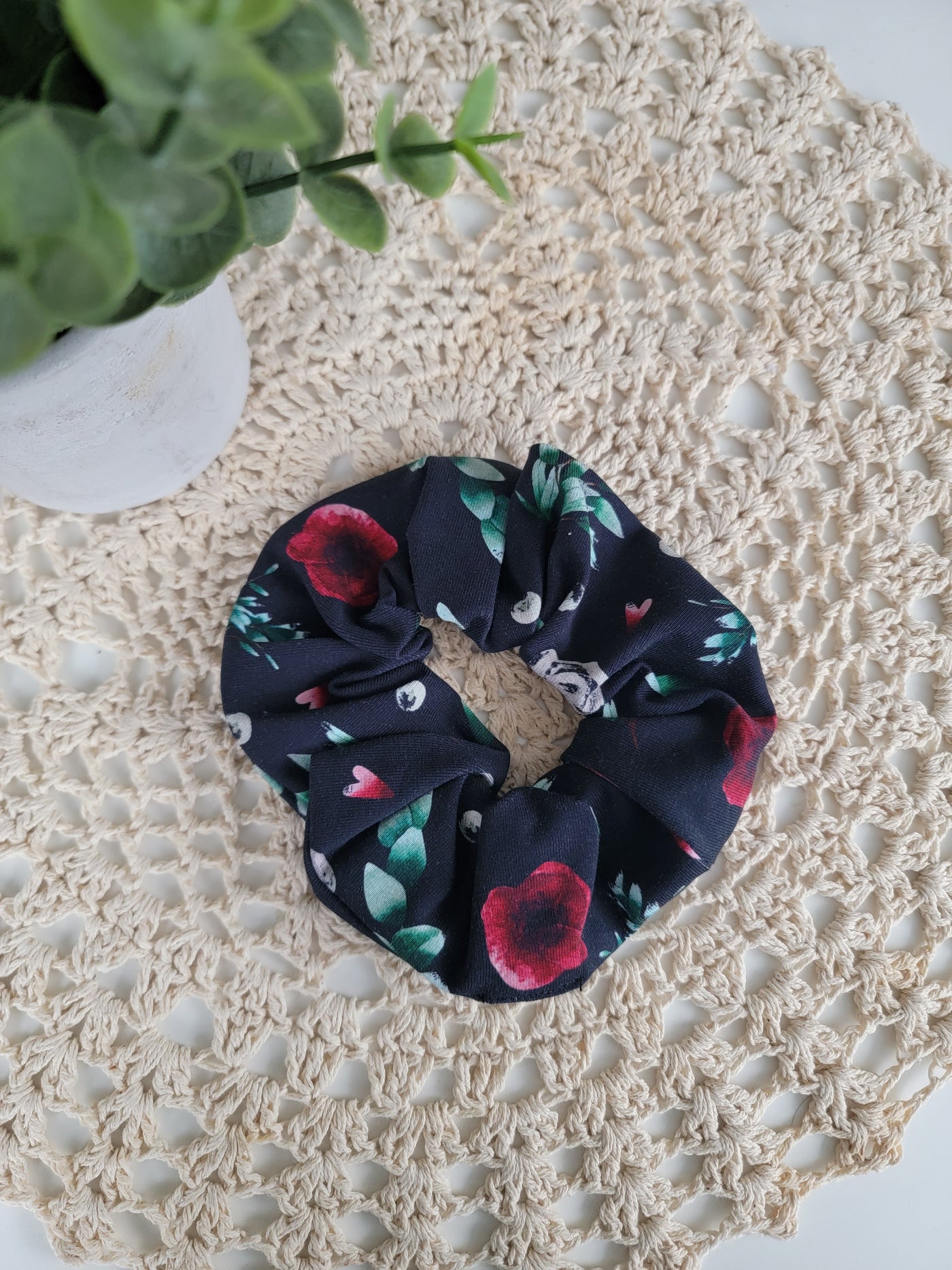 Chouchou fleuri rouge , feuilles vertes sur noir